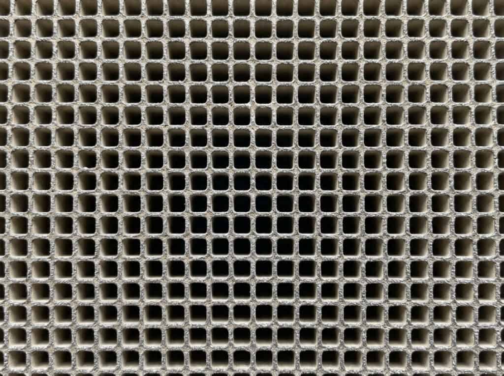 Catalytic Converter Scrap Prices: What Buyers Look For 3 Close-up of a catalytic converter mesh screen showing a grid pattern, used in automotive exhaust systems to reduce emissions and improve engine performance.