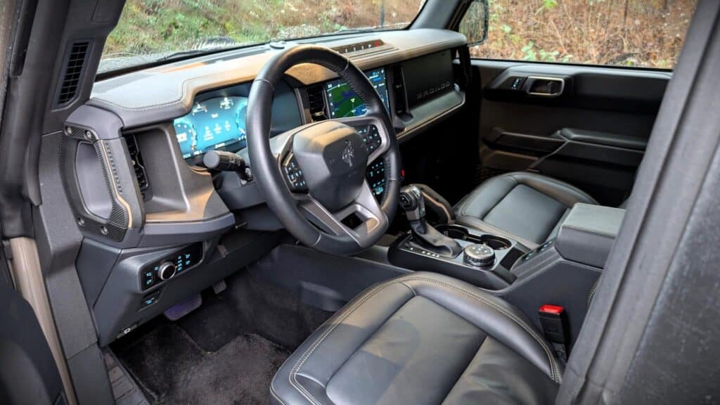 A sleek interior view of the 2026 Ford Bronco Badlands 4-Door, showcasing modern dashboard, digital instrument cluster, and comfortable leather seats designed for off-road adventures and daily driving.