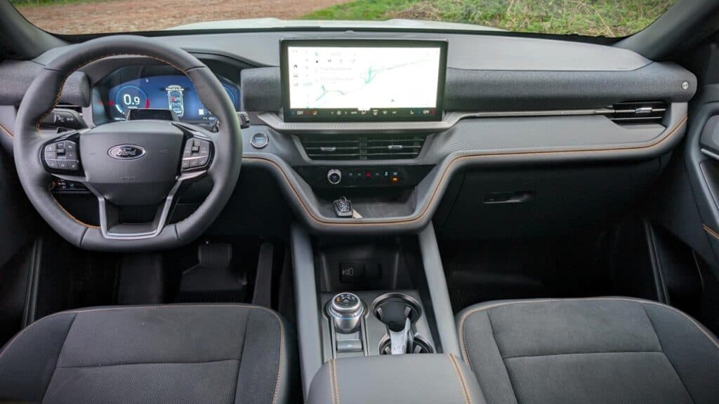 A sleek modern car interior featuring a digital dashboard, a large central touchscreen display with navigation, and ergonomic seats, emphasizing advanced technology and comfort.
