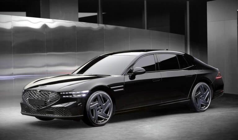 A sleek black 2026 Genesis G90 Prestige luxury sedan parked indoors with modern architecture background, highlighting premium design and advanced features.