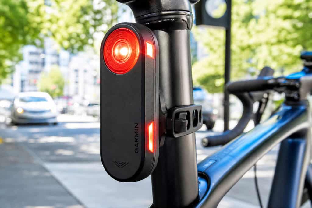 Bike safety light attached to a bicycle post with red warning signal illuminated, emphasizing the importance of visibility and safety for cyclists to prevent accidents and legal issues.