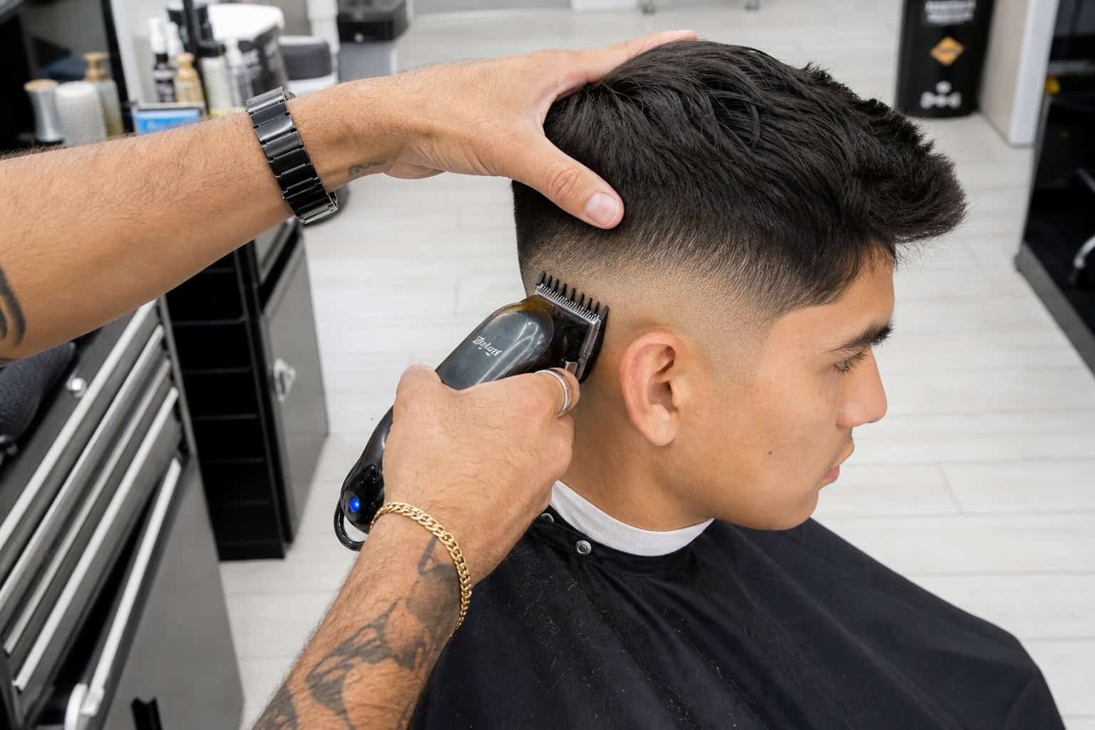 Barber using clippers to create a sharp skin fade on a man's hair.