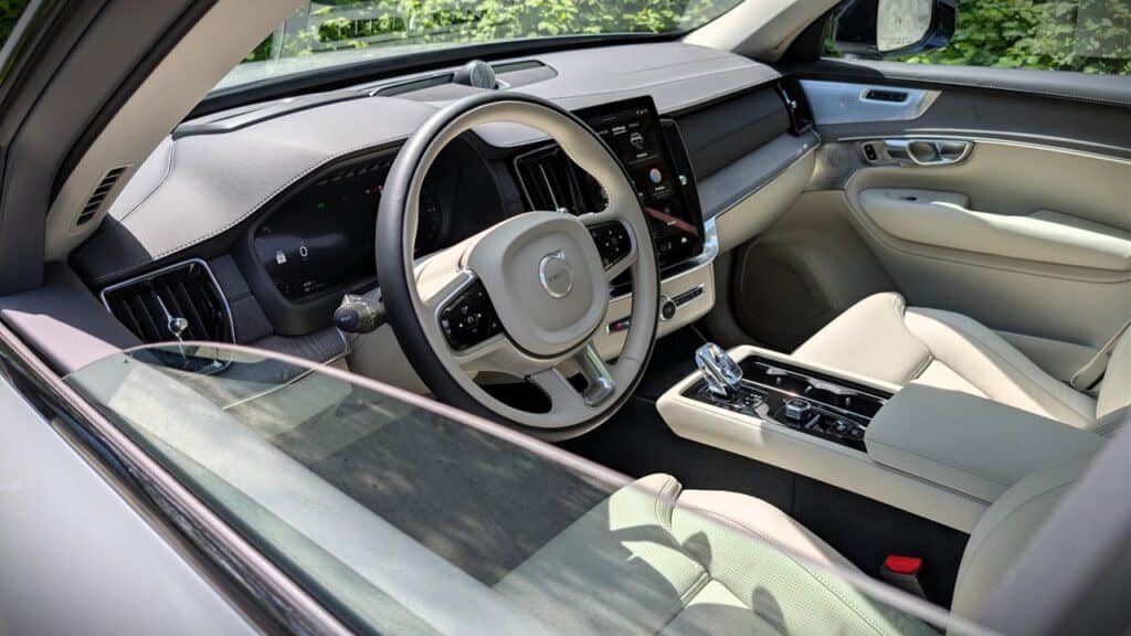 A comfortable modern car interior featuring a sleek dashboard, steering wheel, and center console with advanced controls and a panoramic view through the windshield.