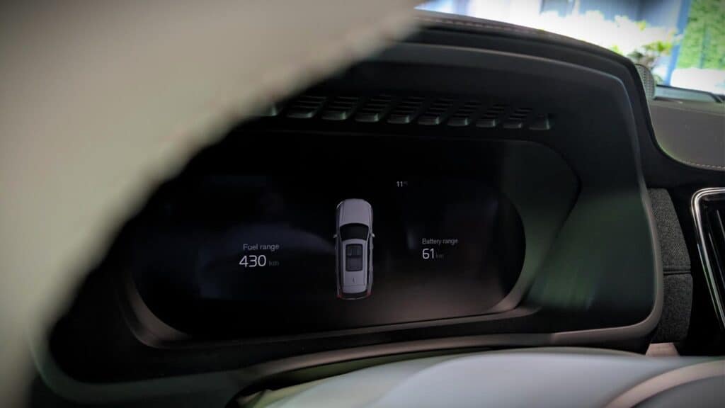 A detailed view of a modern car's digital dashboard displaying fuel range at 430 miles and battery charge at 61%, highlighting advanced vehicle technology and eco-friendly features.