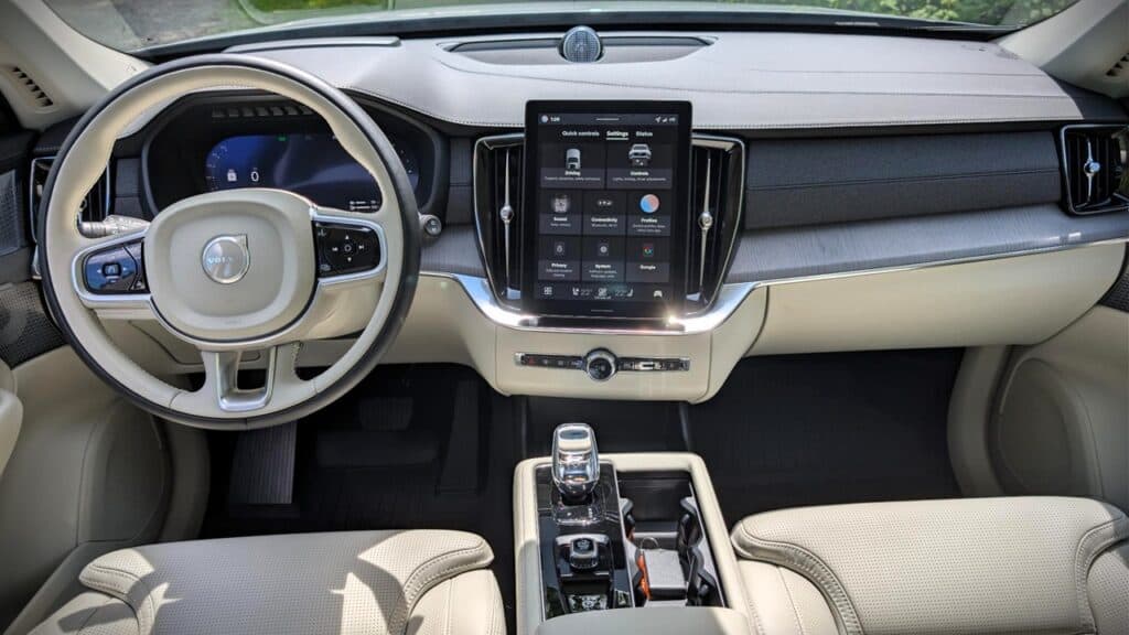 A modern car interior featuring a digital dashboard, a large central touchscreen display, and a sleek gear shifter, emphasizing advanced technology and contemporary design.