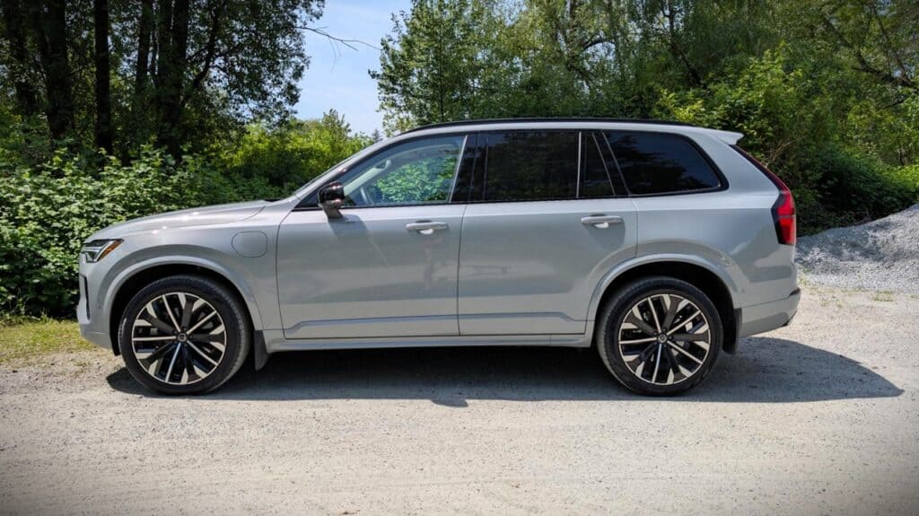 Modern silver SUV parked on a gravel road surrounded by green trees and foliage, showcasing a sleek design and spacious interior for outdoor adventures and family trips.