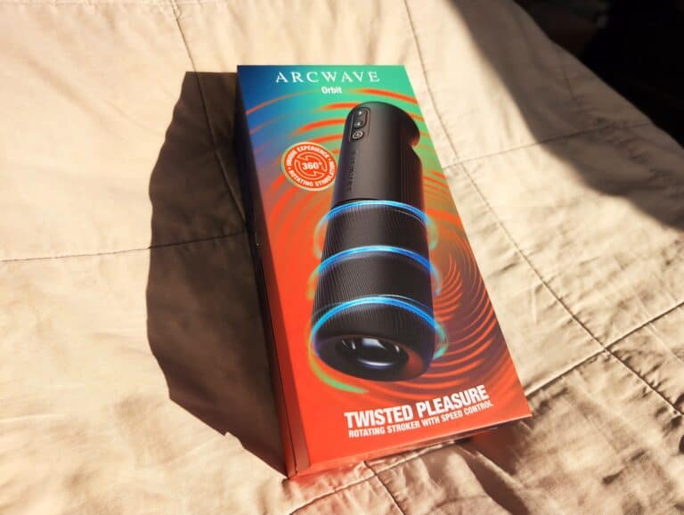Arcwave Orbit packaging box with rotating stroker device on a beige fabric surface.