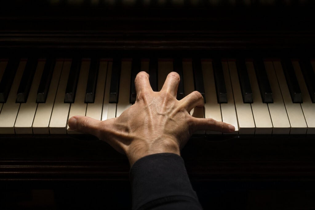 What Are Manly Hands? The Science of Digit Ratio and Why Your Hands Are Fine 5 Close-up of a hand playing piano keys, showcasing musical skill and artistry, ideal for music lovers and piano enthusiasts.