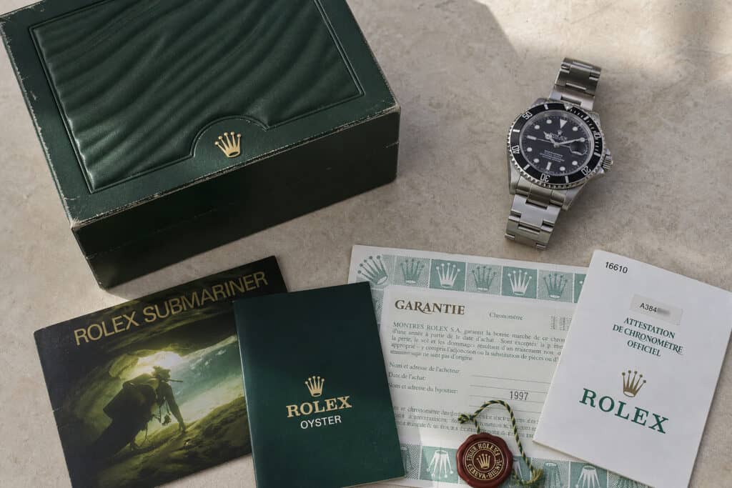 High-quality Rolex Submariner watch with original box, warranty papers, and accessories for luxury watch enthusiasts.