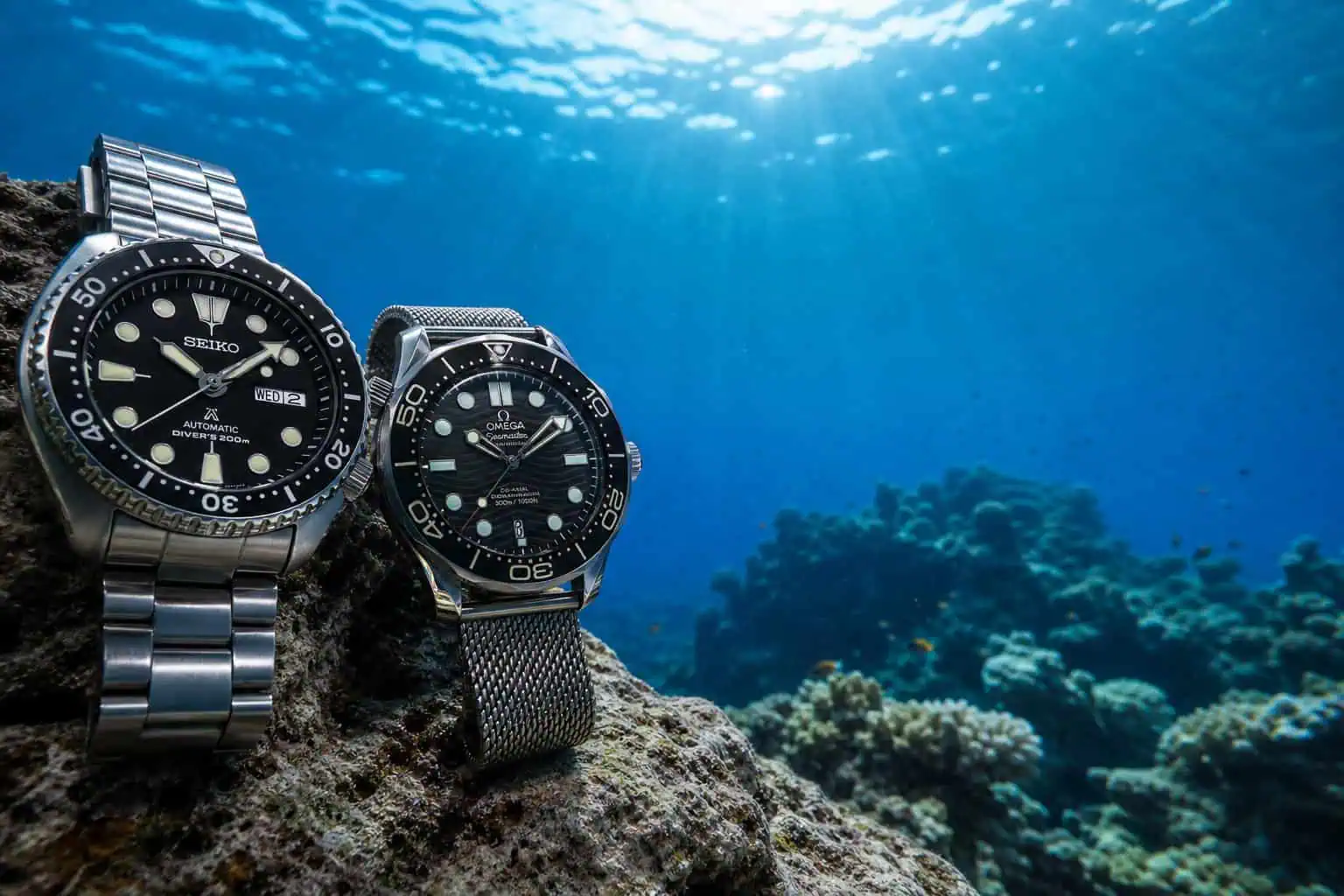 Omega vs Rolex History: 176 Years of Rivalry From NASA to Everest 8 Omega and Rolex dive watches underwater representing their depth record rivalry.