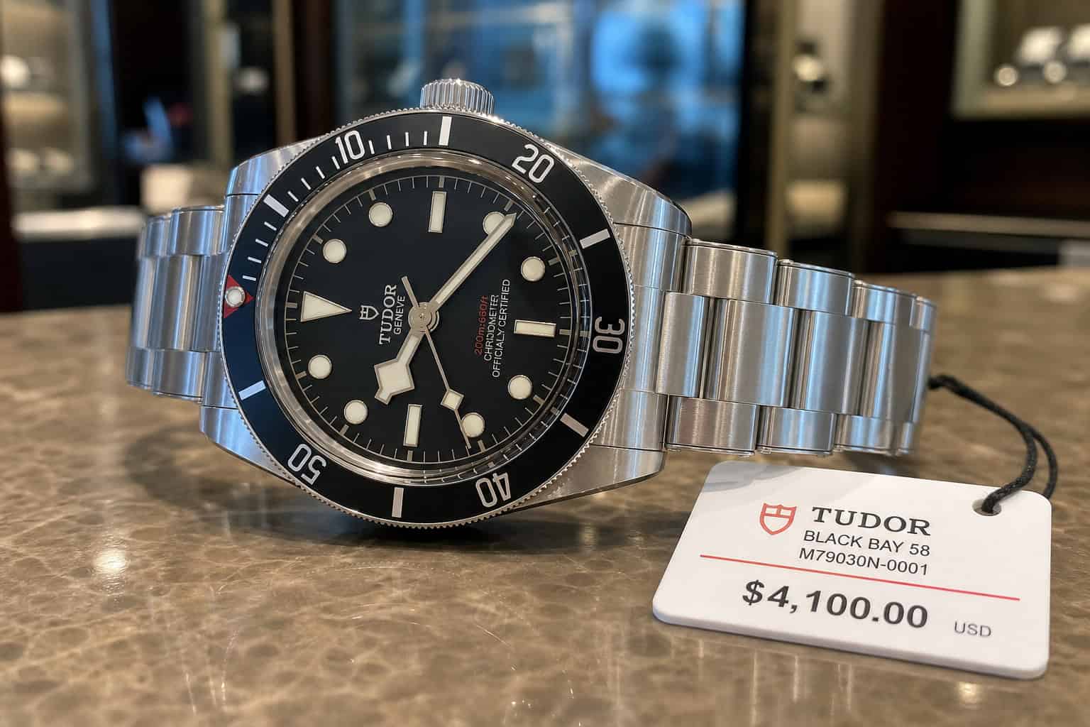 Omega vs Rolex History: 176 Years of Rivalry From NASA to Everest 10 Rolex steel sport watch on counter representing scarcity waitlist and secondary market value.