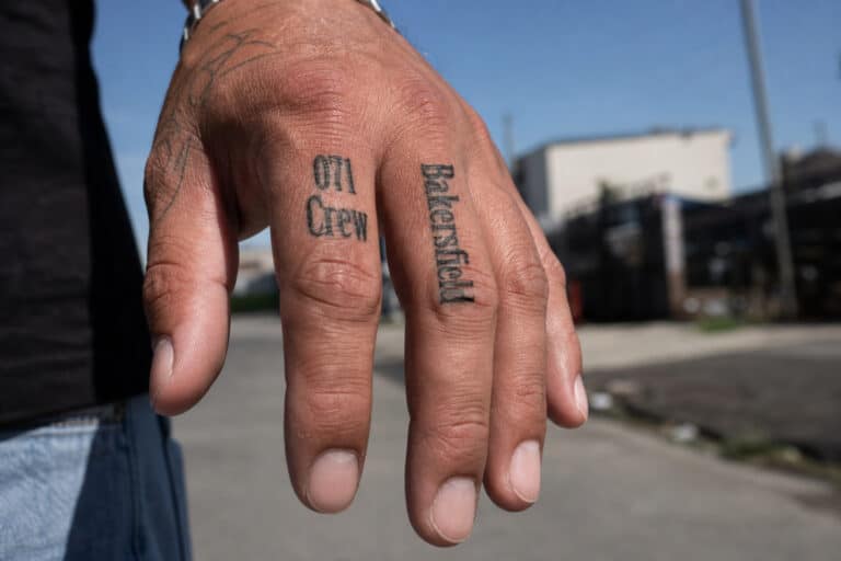 Close-up of Shia LaBeouf's right middle finger with 071 Crew and Bakersfield tattoos.