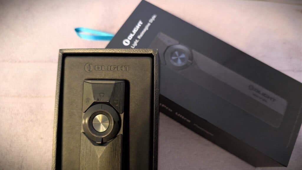 Olight ArkPro Ultra EDC Flashlight Review 9 Olight ArkPro Ultra EDC Flashlight in its packaging, showcasing a sleek black design with a circular control button.