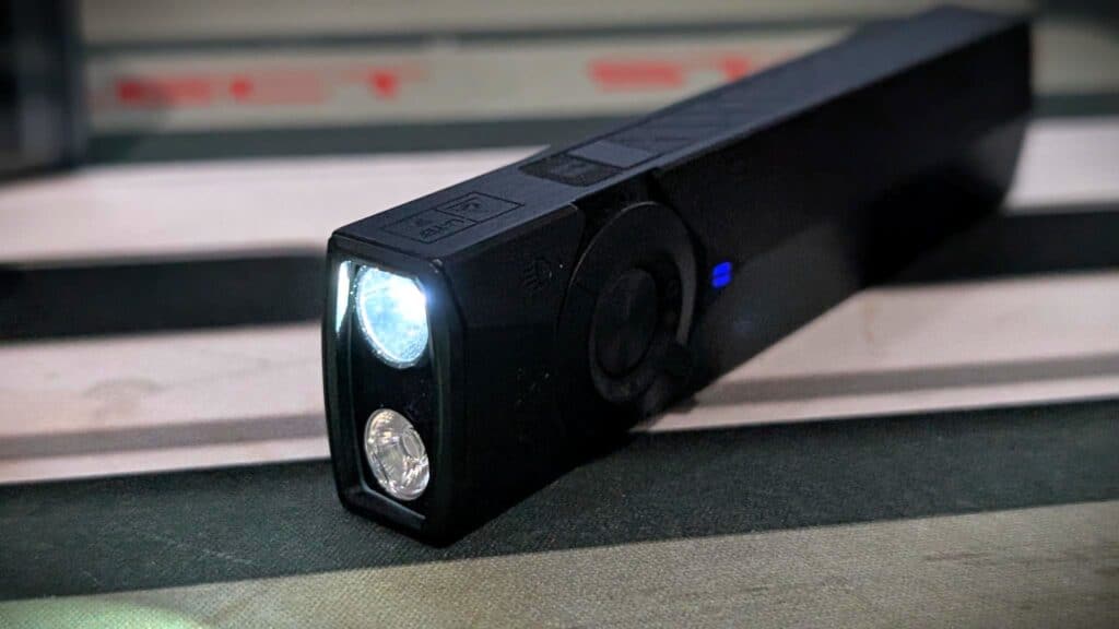 Olight ArkPro Ultra EDC Flashlight Review 11 Olight ArkPro Ultra EDC Flashlight with bright LED light on, black compact design, suitable for everyday carry and outdoor use.