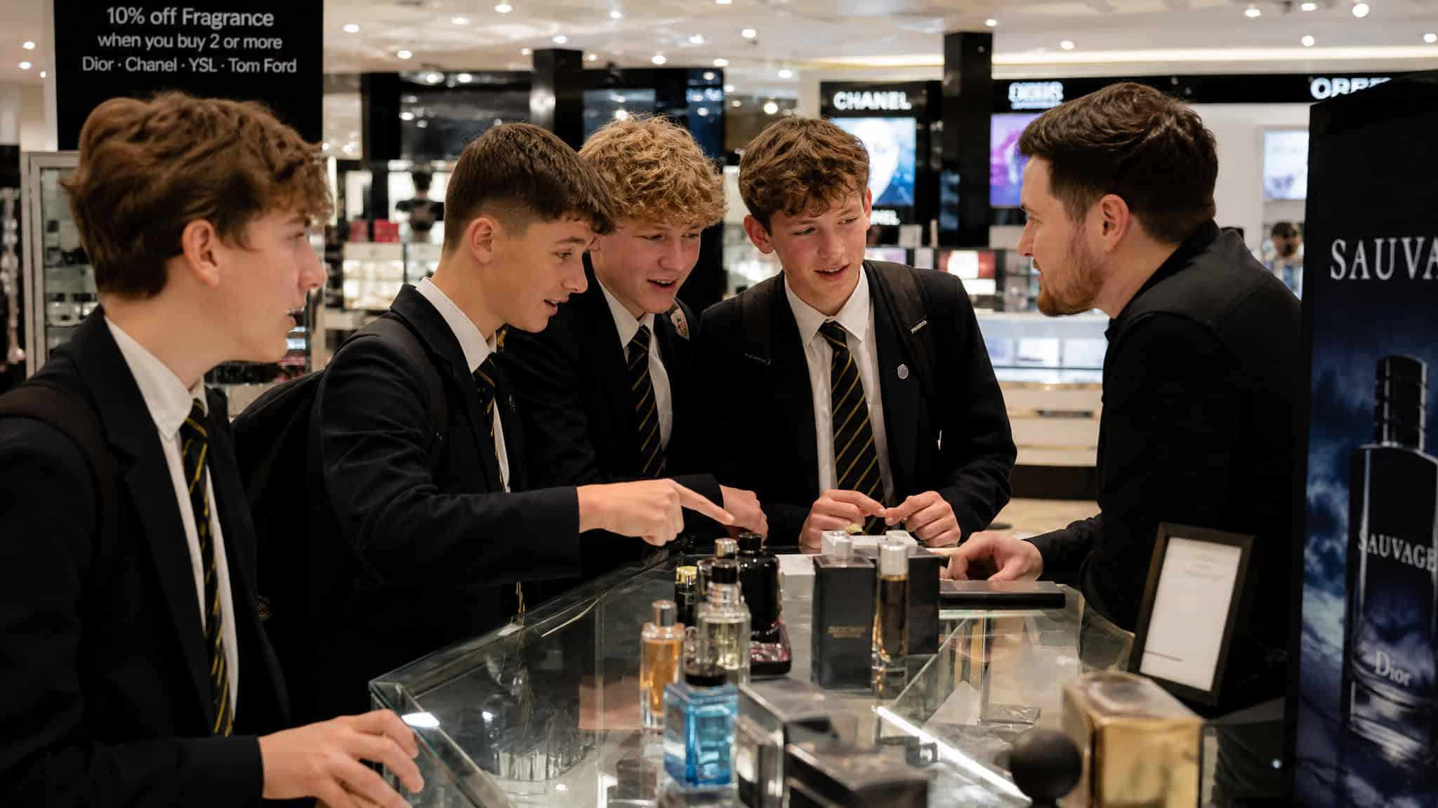 Perfume Obsessed Person: What Defines Them, Really 3 Teenage boys discussing cologne with a sales assistant at a store counter