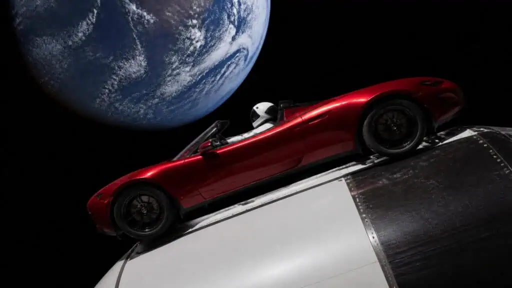 Red Tesla Roadster flying in space with Earth in the background, symbolizing innovation and space exploration.