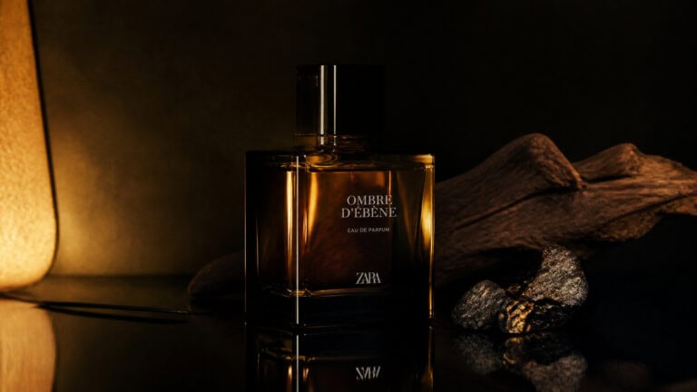 Close-up of Zara Ombre D'Ebene perfume bottle with dark background and textured rocks for a luxurious aesthetic.