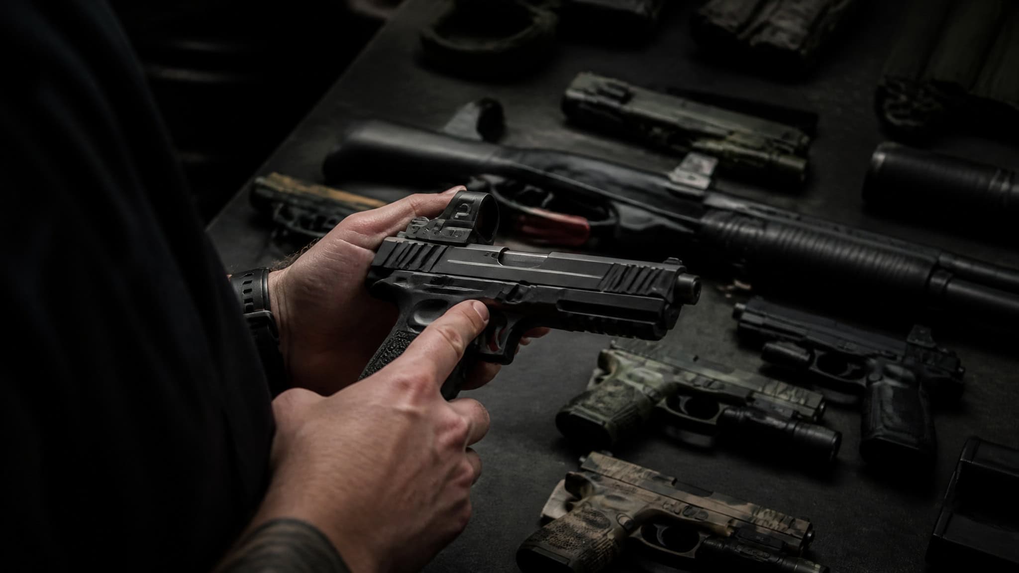 Jason Bourne vs John Wick: Who Wins in a Real Fight? 2 John Wick's curated pistol and shotgun loadout on a table