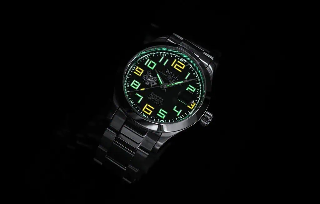 BALL Watch Engineer III Army: How the Four Versions Really Differ 3 Ball Engineer III Army watch with luminous green and yellow numerals and hands, black dial, and stainless steel bracelet on a dark background.