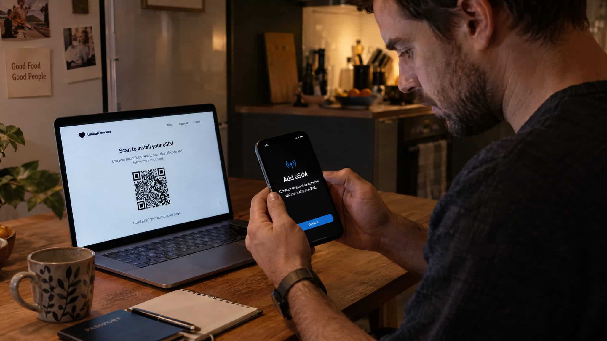 Reddit's Take on Travel eSIMs: Real Traveler Experiences From India 4 A man scanning a QR code on his smartphone in a modern kitchen setting, with a laptop displaying a QR code on the screen.