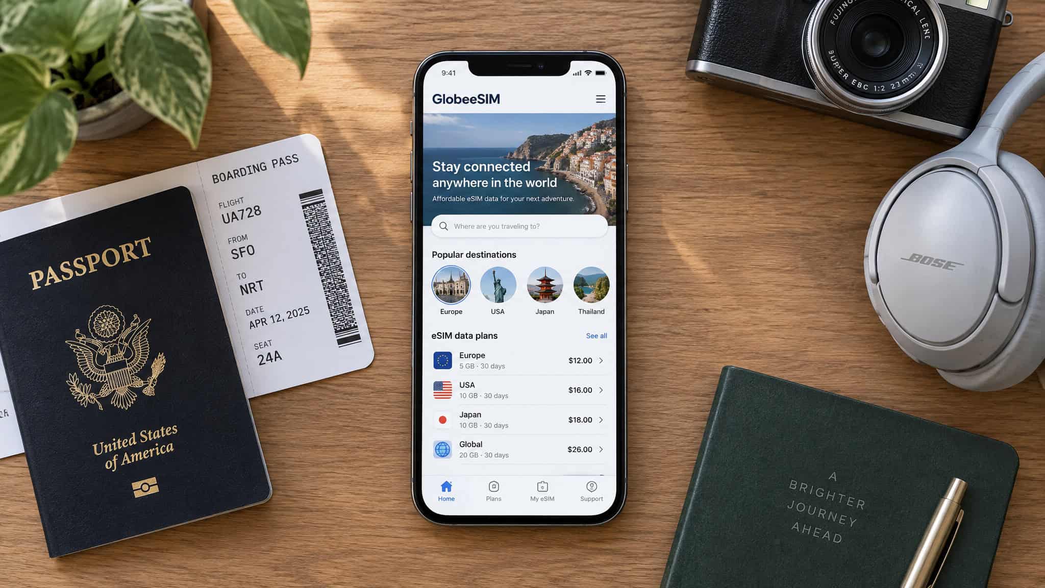 Do You Turn Off Roaming When Using an eSIM? The Per-Line Answer 4 A flat lay of travel essentials including a passport, boarding pass, smartphone, camera, headphones, and a notebook on a wooden surface.