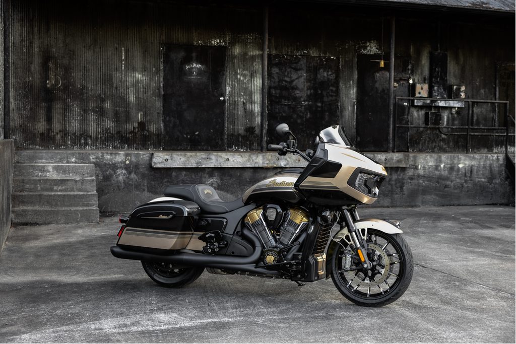 Black and white Indian Motorcycle with Jack Daniel's branding parked against an industrial wall.