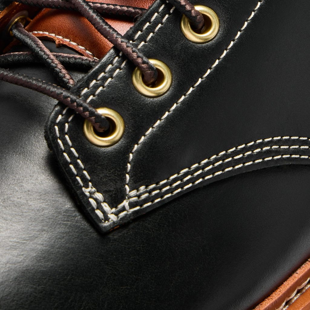 OluKai x Neil Kamimura Limited Edition 'Pāhi' Boots: Price, Release Date, and the Bladesmith Behind the Drop 5 Close-up of OluKai x Neil Kamimura 'Pāhi' boots showing black leather, white stitching, and gold eyelets for laces.