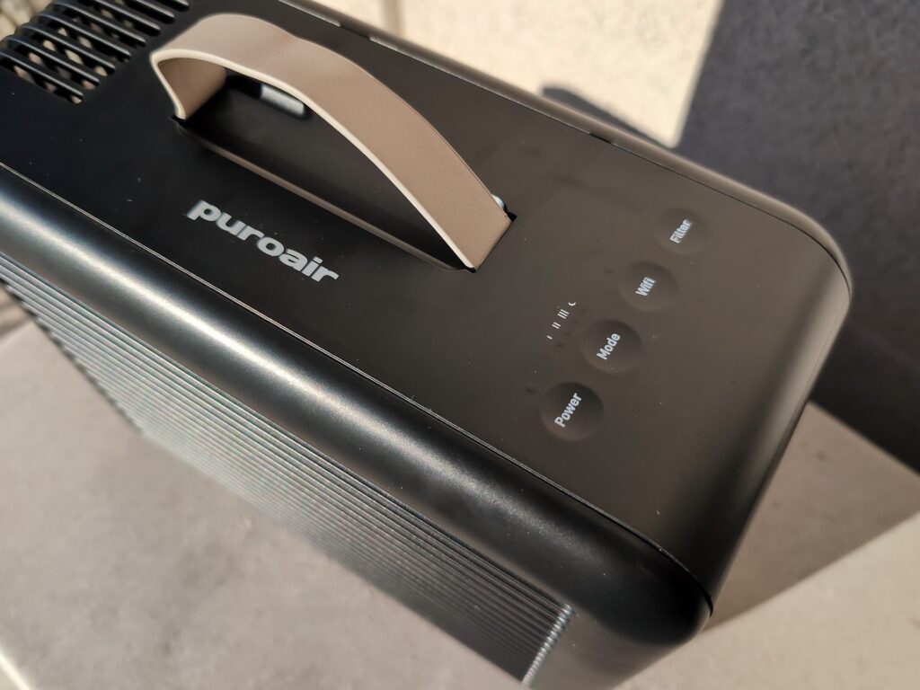 PuroAir 100i HEPA Smart Air Purifier Review: What the 240's Failed Testing Means 3 Close-up of the PuroAir 100i HEPA smart air purifier with control buttons on top, in a modern setting.