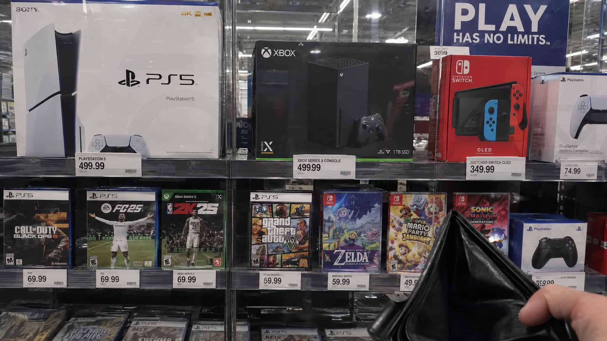 Game consoles and $80 titles on store shelves showing 2026 gaming costs